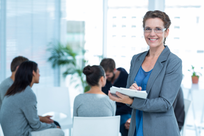 smiling female therapist with group therapy in session